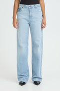 Light blue jeans worn by a person on a white background perfect for sneakers